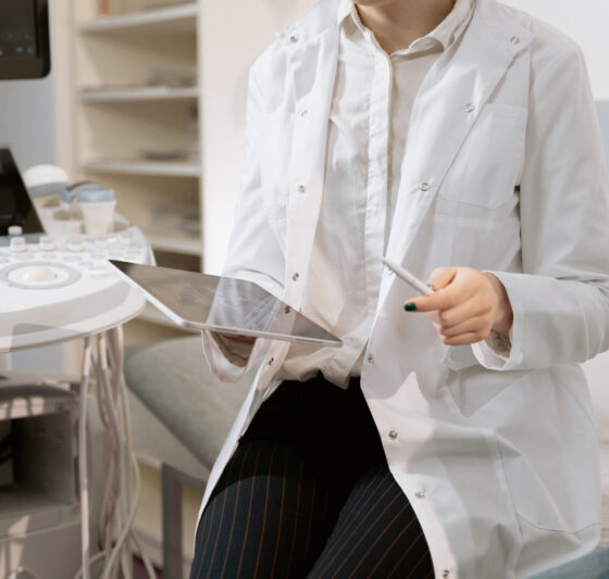 Photo of gynecologist sitting near medical equipment